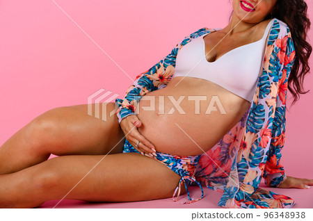 Pregnant happy woman expecting a child caresses her belly 96348938