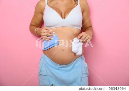 Pregnant mom prepares the clothes for the baby 96348964