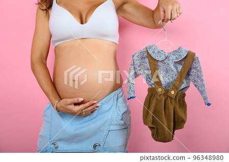 Pregnant mom prepares the clothes for the baby 96348980