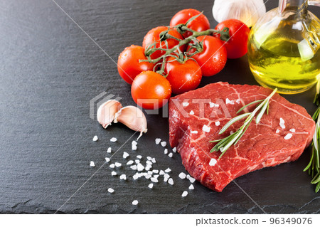 Raw steak with cooking ingridients on black slate background 96349076