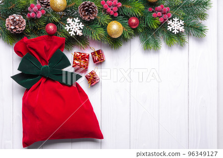 Christmas background with decorated fir tree and red gift bag. Top view, flat lay with copy space Christmas background with decorated fir tree and red gift bag. Top view, flat lay with copy space 96349127