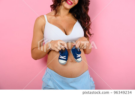 Pregnant happy woman expecting a child caresses her belly 96349234