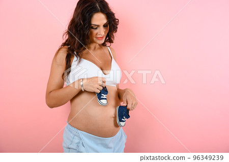 Pregnant woman expecting a child caresses her belly 96349239