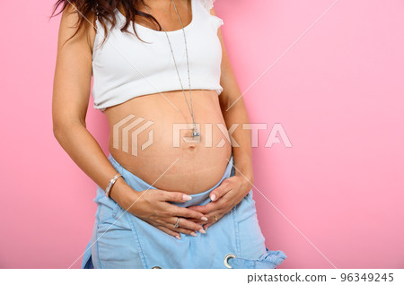 Pregnant woman expecting a child caresses her belly 96349245
