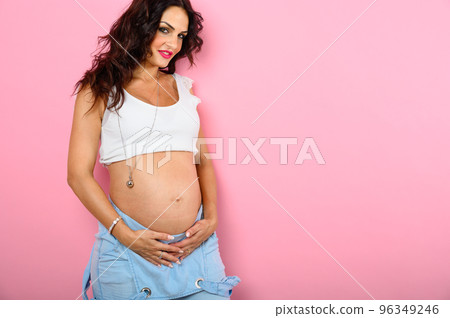 Pregnant happy woman expecting a child caresses her belly 96349246