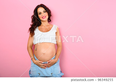Pregnant happy woman expecting a child caresses her belly 96349255