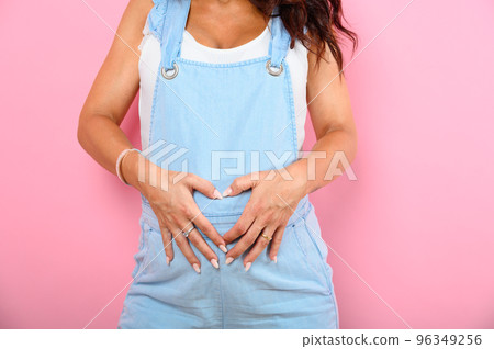 Pregnant woman expecting a child caresses her belly 96349256