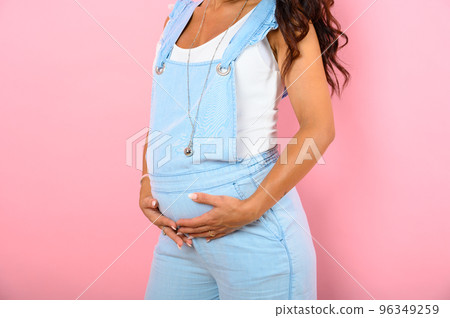 Pregnant woman expecting a child caresses her belly 96349259