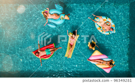 Friends in swimsuit in the pool getting a tan 96349281