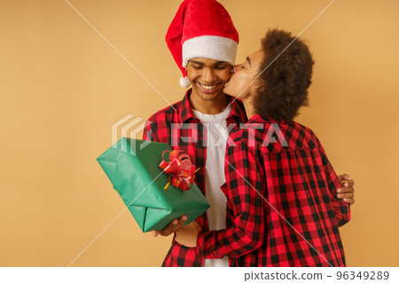 Happy and joyful afro couple exchange christmas present Happy and joyful afro couple exchange christmas present 96349289