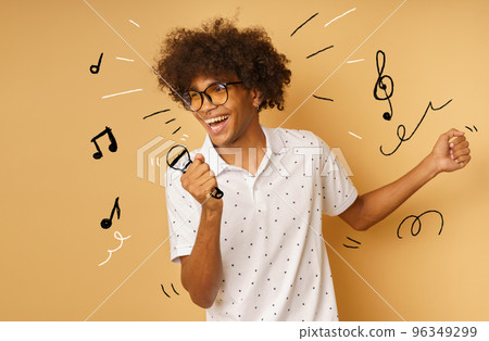 Afro happy man with microphone sing a song Afro happy man with microphone sing a song 96349299