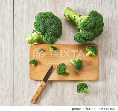 Cooking healthy food, cutting broccoli for baking on a white table, top view. Fresh green broccoli on a table, top view. 96349300