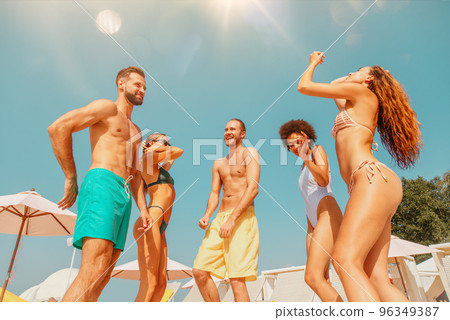 Group of friends in swimsuit dance music in a swimming pool 96349387