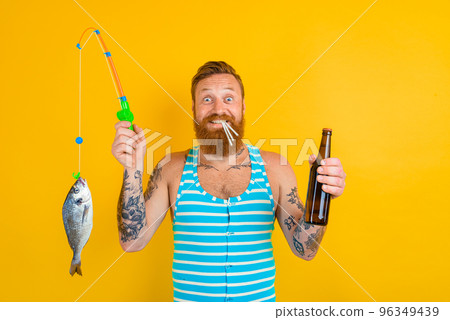 man with beard and swimsuit caught a fish man with beard and swimsuit caught a fish 96349439