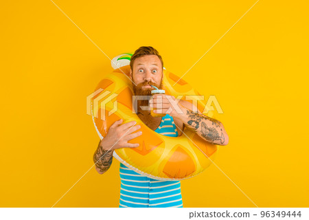 man with life buoy of child drinks a fruit juice 96349444