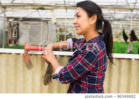 woman gardener worker standing with rake woman gardener worker standing with rake 96349882