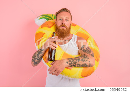 Serious man is ready to swim with a donut lifesaver with beer and cigarette in hand 96349982