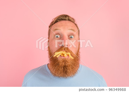 Hungry man with beard and tattoos eats fried potatoes 96349988