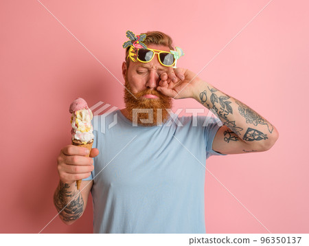 Cry man with beard and tattoos does not like the icecream Cry man with beard and tattoos does not like the icecream 96350137