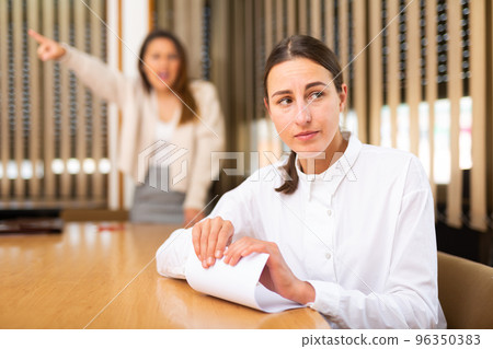 Unhappy female office employee after reprimand from angry chief 96350383