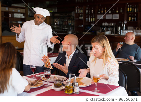 Upset couple complaining to chef about pizza quality 96350671