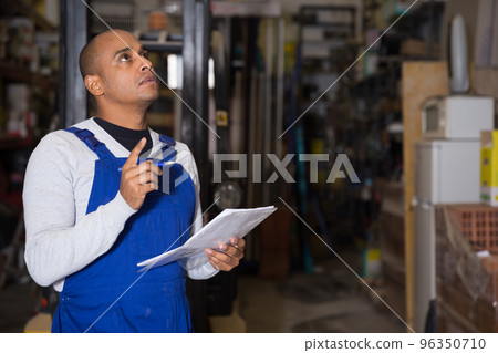 Confident worker taking inventory in building materials store 96350710