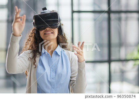 positive woman wearing virtual reality goggles headsetConnection, technology, new generation, progress concept. positive woman wearing virtual reality goggles headsetConnection, technology, new generation, progress concept. 96350874