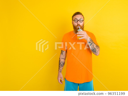 Nerd amazed man with glasses drinks a fruit juice 96351199