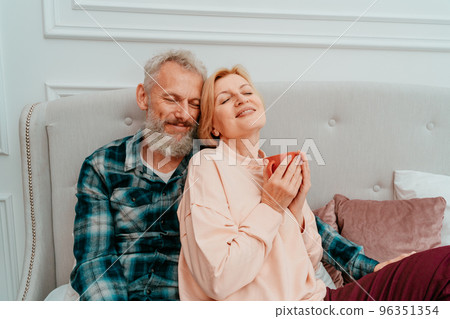 husband and wife have breakfast with coffee on the bed at home 96351354