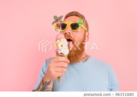 Hungry man with beard and tattoos eats a big icecream 96351880