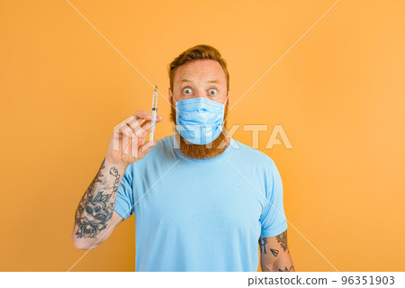 Afraid man with beard, tattoo and mask for covid-19 is ready for the virus vaccine 96351903