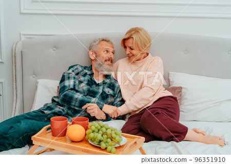 husband and wife have breakfast on the bed with coffee and fruit 96351910