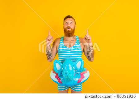 man with inflatable donut with elephant is ready to swim 96351920