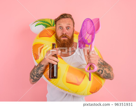 Afraid man is ready to swim with a donut lifesaver with beer and cigarette in hand 96351931