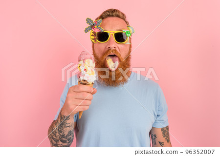 Hungry man with beard and tattoos eats a big icecream 96352007