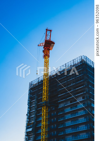 建設中的高層公寓高聳的起重機和晴朗的天空垂直高飽和度對比 建設中的高層公寓高聳的起重機和晴朗的天空垂直高飽和度對比 96352098