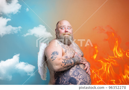 Fat amazed man with beard ,tattoos and wings acts like an angel Fat amazed man with beard ,tattoos and wings acts like an angel 96352278