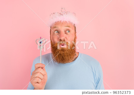 Thoughtful man with beard and tattoos acts like a princess of a tale 96352373