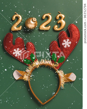Festive layout numbers 2023, accessories New Year, wreath of horns green background 96352794