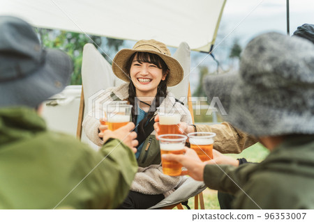 Asian men and women drinking beer and partying with friends at a campsite in autumn and winter 96353007