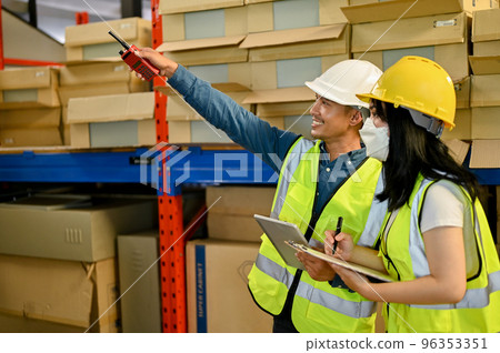 Professional adult Asian male warehouse manager and female worker are working together 96353351