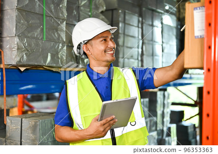 Smart Asian foreman or warehouse worker is working in a warehouse, using tablet Smart Asian foreman or warehouse worker is working in a warehouse, using tablet 96353363