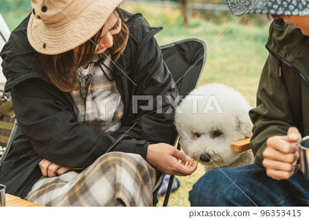 Couple campers cooking with their dog at the autumn/winter campsite 96353415