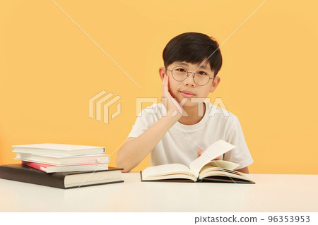 手托下巴的兒童學生概念和課桌上打開的書 96353953
