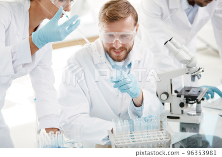 laboratory staff comparing liquid in laboratory tubes . 96353981