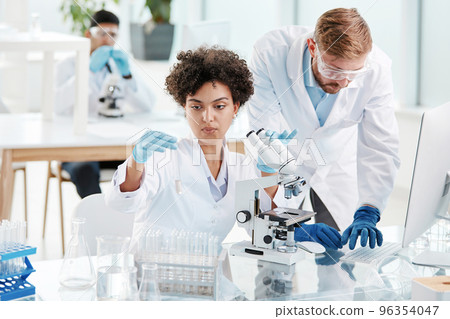 team of research scientists conducts research in a modern laboratory team of research scientists conducts research in a modern laboratory 96354047
