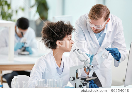 female scientist and her colleague are conducting research in the laboratory . female scientist and her colleague are conducting research in the laboratory . 96354048