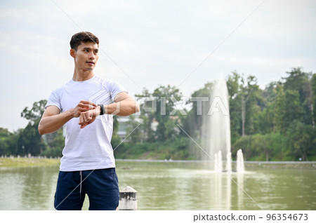 Handsome young Asian athletic man in sportswear with his smartwatch. 96354673