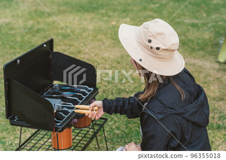 Asian camper making hot sandwiches for camping food at autumn winter camp Asian camper making hot sandwiches for camping food at autumn winter camp 96355018
