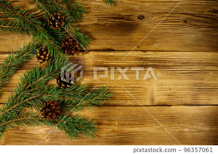 Christmas composition with fir tree branches and cones on wooden background. Top view, copy space Christmas composition with fir tree branches and cones on wooden background. Top view, copy space 96357061
